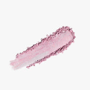 ProtoClinical k-beauty DEAR DAHLIA Skin Luminous Highlighter shown as a soft pink highlighter swatch spread horizontally on a light background