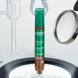ProtoClinical k-beauty LABO-H Scalp Strengthening Clinic Hair Line Ampoule Hair Loss Care 15ML standing upright in green and brown pen-style packaging on a lit circular platform with glass lab tools