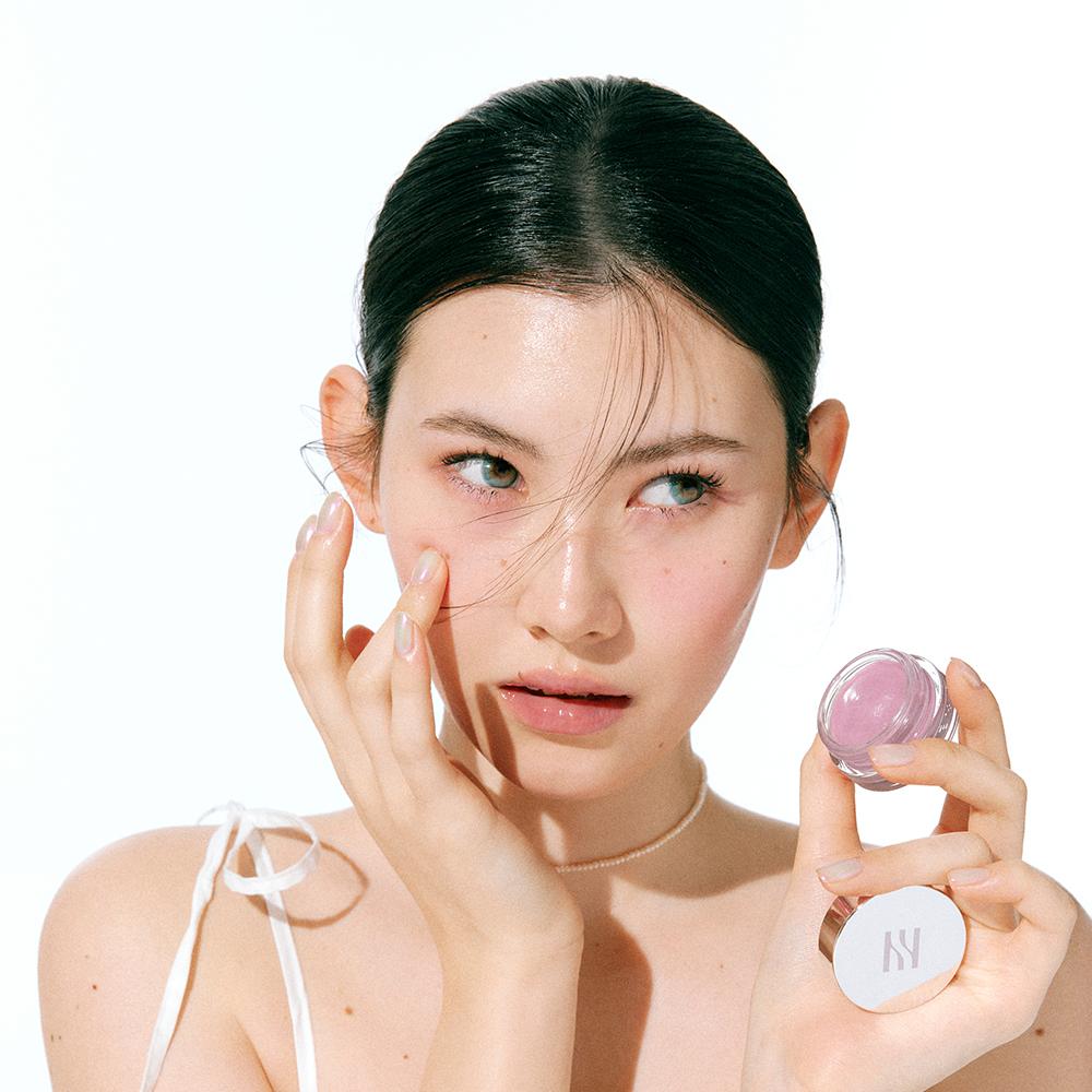 ProtoClinical k-beauty HERA Sensual Lip & Cheek 7g model portrait featuring rosy lip and cheek makeup on a light background.