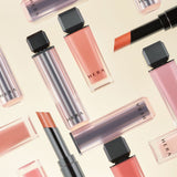 ProtoClinical k-beauty HERA Sensual Powder Matte Lipstick 3g beige beauty graphic with one tall taupe silhouette and two smaller taupe silhouettes on a light background.