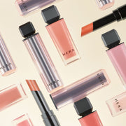 ProtoClinical k-beauty HERA Sensual Powder Matte Lipstick 3g beige beauty graphic with one tall taupe silhouette and two smaller taupe silhouettes on a light background.