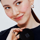 ProtoClinical k-beauty HERA Skin Tint Comfy Spreader SPF50/ PA++++ 15g portrait-style beauty visual with warm skin tones and teal side accents.