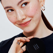 ProtoClinical k-beauty HERA Skin Tint Comfy Spreader SPF50/ PA++++ 15g portrait-style beauty visual with warm skin tones and teal side accents.