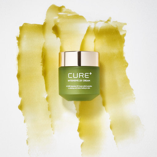 ProtoClinical k-beauty [KIM JEONG MOON Aloe] Cure Plus Intensive 2X Cream 50g as a single yellow-green cream package shown at a slight angle on a pale yellow and lavender background