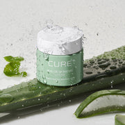 ProtoClinical k-beauty [KIM JEONG MOON Aloe] Cure Realoe Signature Cream 55g as a single pale mint cream package centered upright above a dark green base on a soft pink background