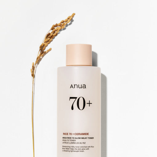ProtoClinical k-beauty Anua Rice 70 Glow Milky Toner 250ml single upright pale beige toner bottle centered on a pale blue and peach background