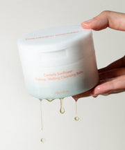 ProtoClinical k-beauty warm orange beauty product silhouette with soft green accents on a beige background.
