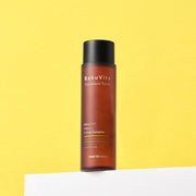ProtoClinical k-beauty yellow beauty product silhouette with an olive vertical center and a soft lavender-gray base on a light background.