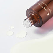 ProtoClinical k-beauty muted rose beauty detail with a deep plum circular center on a pale background.