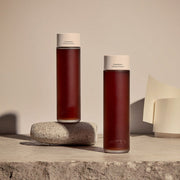 ProtoClinical k-beauty warm beige beauty graphic with soft brown vertical bands on a tan background.