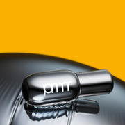 ProtoClinical k-beauty primera Retinol Volume Lip Serum 12g in a reflective silver bottle lying sideways on a mirrored surface against a vivid yellow background