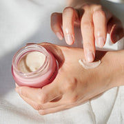 ProtoClinical k-beauty warm peach beauty product detail with pale blue side tones on a light background.