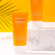 ProtoClinical k-beauty warm orange beauty product detail with a soft white top and pale blue lower edge on a light background.
