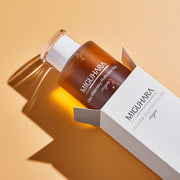 ProtoClinical k-beauty warm beige beauty product detail on a soft peach and pale blue background.
