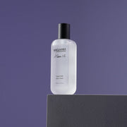 ProtoClinical k-beauty dark lavender beauty product silhouette with a soft pale vertical center on a muted background.
