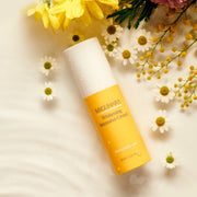 ProtoClinical k-beauty warm gold beauty product detail with a beige vertical center on a pale blue background.