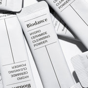 ProtoClinical k-beauty soft gray beauty graphic with layered white and charcoal bands on a light background.