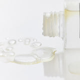 ProtoClinical k-beauty soft beige beauty packaging with a taupe vertical center on a light background.