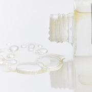 ProtoClinical k-beauty soft beige beauty packaging with a taupe vertical center on a light background.