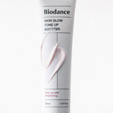 ProtoClinical k-beauty BIODANCE: Skin Glow Tone Up Booster Spf50+ Pa (30ml) with a single dark center package framed by pale side panels on a white background