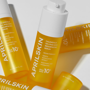 ProtoClinical k-beauty APRILSKIN Calendula PHA + AHA Resurfacing Serum 30ml single upright yellow serum bottle centered on a golden yellow and pale blue background