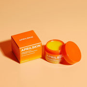 ProtoClinical k-beauty APRILSKIN MINI Carrotene IPMP Hydromelt Cleansing Balm 10ml single orange cleansing balm jar centered on a warm beige background with pale blue side accents.