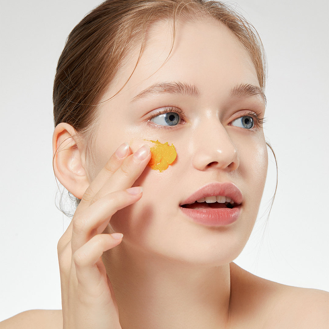 ProtoClinical k-beauty APRILSKIN MINI Carrotene IPMP Hydromelt Cleansing Balm 10ml single orange cleansing balm jar centered on a warm beige background with pale blue side accents.
