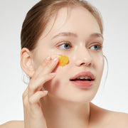 ProtoClinical k-beauty APRILSKIN MINI Carrotene IPMP Hydromelt Cleansing Balm 10ml single orange cleansing balm jar centered on a warm beige background with pale blue side accents.