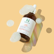 ProtoClinical k-beauty yellow and beige product packaging on a pale blue and cream background.