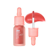 ProtoClinical k-beauty peripera Ink Airy Velvet 4g (NEW #26~#30) single warm coral lip tint swatch in a rounded diamond shape with deeper left-side shading and pale blue corners on a white background