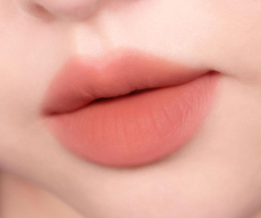 ProtoClinical k-beauty peripera Over Blur Tint 3.5g shade 01 Warm Bassador shown as a single horizontal lip tint swatch on a pale beige background