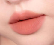 ProtoClinical k-beauty peripera Over Blur Tint 3.5g shade 01 Warm Bassador shown as a single horizontal lip tint swatch on a pale beige background
