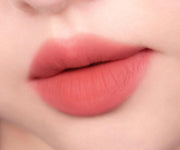 ProtoClinical k-beauty peripera Over Blur Tint 3.5g shade 04 Coral-La-La shown as a single horizontal coral lip tint swatch on a pale beige background