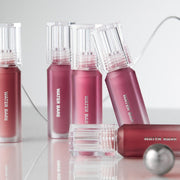 ProtoClinical k-beauty peripera PERIPERA Water Bare Tint trio of mauve lip tint packages lined up side by side on a pale blue and taupe background