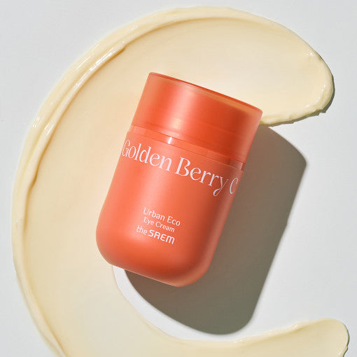 ProtoClinical k-beauty The SAEM Urban Eco Golden Berry C Eye Cream 30ml coral-orange eye cream jar angled over a pale cream swirl on a light gray background
