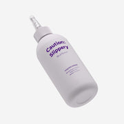 ProtoClinical k-beauty withbecon Caution Slippery Hair Treatment 300ml as a single tall gray treatment bottle angled on a pale lavender background