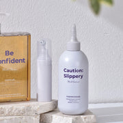 ProtoClinical k-beauty withbecon Caution Slippery Hair Treatment 300ml single upright pale gray treatment bottle centered between warm beige and pale blue side panels