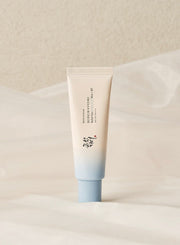 ProtoClinical k-beauty [Beauty of Joseon] Relief Sun Aqua-fresh Rice+B5 (SPF50+ PA++++) 50ml single upright pale blue sunscreen tube centered on a white background with soft peach side accents.
