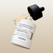 ProtoClinical k-beauty COSRX The Alpha-Arbutin 2 Discoloration Care Serum 50ml single centered serum bottle with a dark cap on a pale beige and gray background