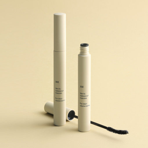 ProtoClinical k-beauty 3CE SLIM FIX WATERPROOF MASCARA 6.5g single slim mascara tube centered on a pale yellow background with soft horizontal bands
