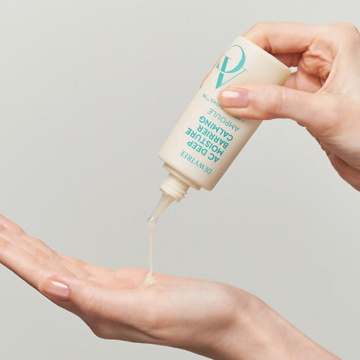ProtoClinical k-beauty DEWYTREE AC Deep Moisture Barrier Calming Ampoule 60ml upside-down cream bottle dispensing ampoule into an open palm, with an aqua cap and bare hands on a light background
