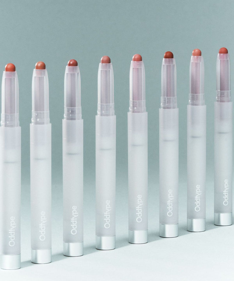 ProtoClinical k-beauty Oddtype New Rules Blur Balm single upright dark gray blur balm package centered on a pale blue-gray background