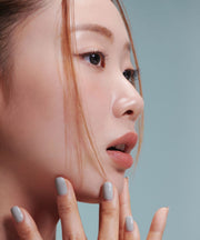 ProtoClinical k-beauty Oddtype New Rules Blur Balm single vertical peach-beige lip balm swatch with taupe side shading and aqua edge panels on a light background