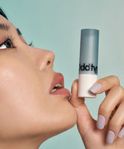 ProtoClinical k-beauty Oddtype Over the Natural Lip Balm warm peach and taupe lip balm detail with a soft aqua top fade in a vertical close-up