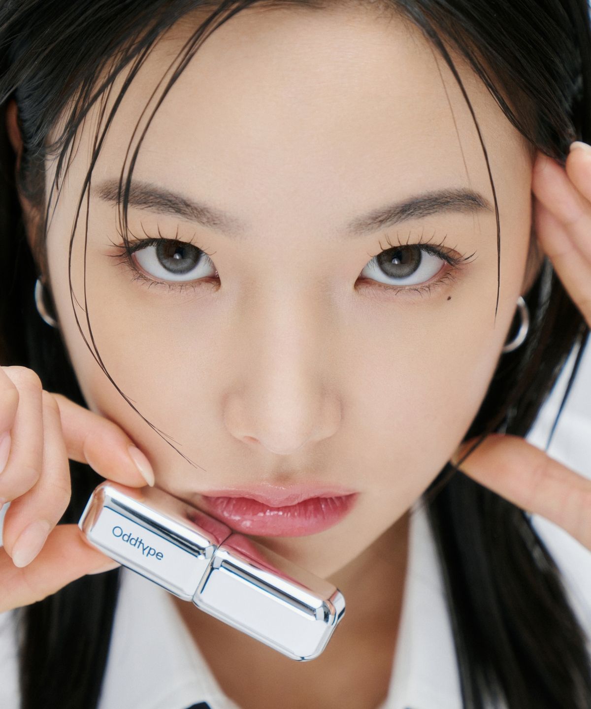 ProtoClinical k-beauty Oddtype Unscene Dew Glow Balm dark gray vertical lip balm detail with pale teal side panels on a light background