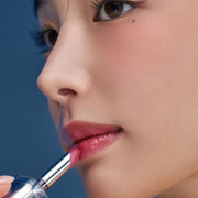 ProtoClinical k-beauty Oddtype Unseen Balloon Tint single upright lip tint tube centered on a navy and peach background