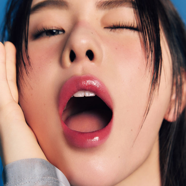 ProtoClinical k-beauty Oddtype Unseen Mirror Tint single upright coral lip tint tube centered on a warm nude background with dark side gradients