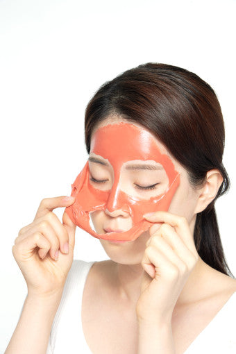 ProtoClinical k-beauty PAUL MEDISON Deep Red Pore Peel Off Pack 155ml model peeling a coral-red face mask from her cheeks on a white background