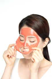 ProtoClinical k-beauty PAUL MEDISON Deep Red Pore Peel Off Pack 155ml model peeling a coral-red face mask from her cheeks on a white background