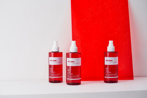 ProtoClinical k-beauty PAUL MEDISON Signature Body Mist 211ml #Baby Powder three translucent pink-red body mist bottles lined up on a white surface with a bright red rectangular backdrop